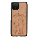 Coque de protection en bois véritable fabriquée en France pour Google Pixel 4 sur le thème de la montagne, du ski et de la neige avec un motif représentant une paire de ski plantée dans la neige avec en fond des montagnes enneigées