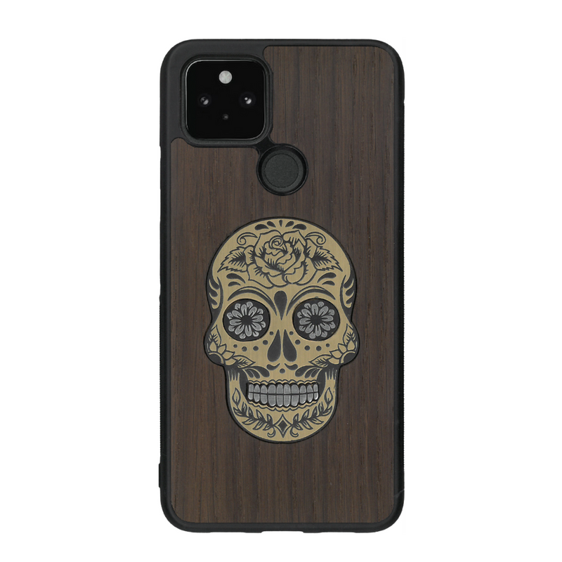 Coque de protection en bois véritable fabriquée en France pour Google Pixel 4a 5g alliant du chêne fumé avec du métal argenté et doré représentant une tête de mort mexicaine sur le thème Dia de los Muertos