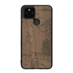 Coque de protection en bois véritable fabriquée en France pour Google Pixel 4a 5g sur le thème de la randonnée en montagne et de l'aventure avec une gravure représentant une femme de dos face à un paysage de nature