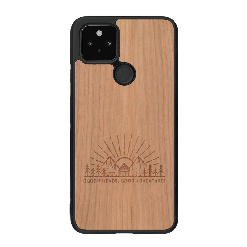 Coque de protection en bois véritable fabriquée en France pour Google Pixel 4a 5g sur le thème chill et nature avec un motif représentant un levé de soleil sur un paysage de montagne avec des sapins et un chalet et la phrase "Good friends, good adventure"