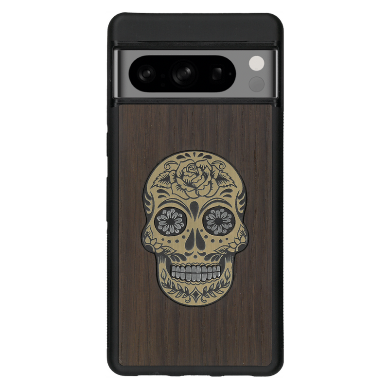 Coque de protection en bois véritable fabriquée en France pour Google Pixel 6 alliant du chêne fumé avec du métal argenté et doré représentant une tête de mort mexicaine sur le thème Dia de los Muertos