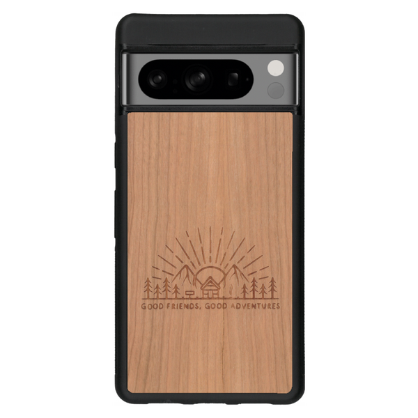 Coque de protection en bois véritable fabriquée en France pour Google Pixel 6 sur le thème chill et nature avec un motif représentant un levé de soleil sur un paysage de montagne avec des sapins et un chalet et la phrase "Good friends, good adventure"