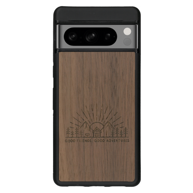 Coque de protection en bois véritable fabriquée en France pour Google Pixel 6 sur le thème chill et nature avec un motif représentant un levé de soleil sur un paysage de montagne avec des sapins et un chalet et la phrase "Good friends, good adventure"