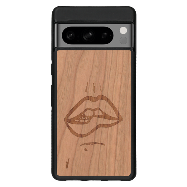 Coque de protection en bois véritable fabriquée en France pour Google Pixel 6a représentant de manière minimaliste une bouche de féminine se mordant le coin de la lèvre de manière sensuelle dessinée à la main par l'artiste Maud Dabs