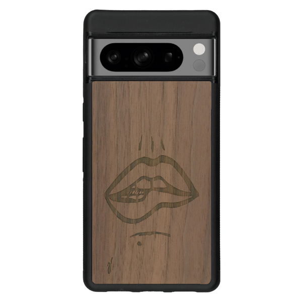 Coque de protection en bois véritable fabriquée en France pour Google Pixel 6a représentant de manière minimaliste une bouche de féminine se mordant le coin de la lèvre de manière sensuelle dessinée à la main par l'artiste Maud Dabs