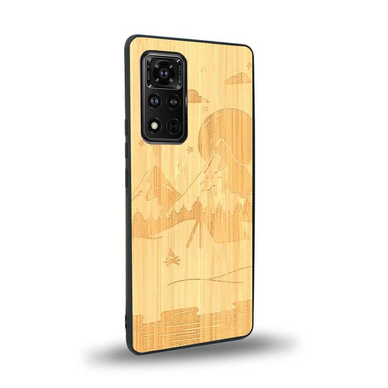 Coque de protection en bois véritable fabriquée en France pour Honor V40 sur le thème du camping en pleine nature représentant une tente avec un feu de camp entouré de montagnes