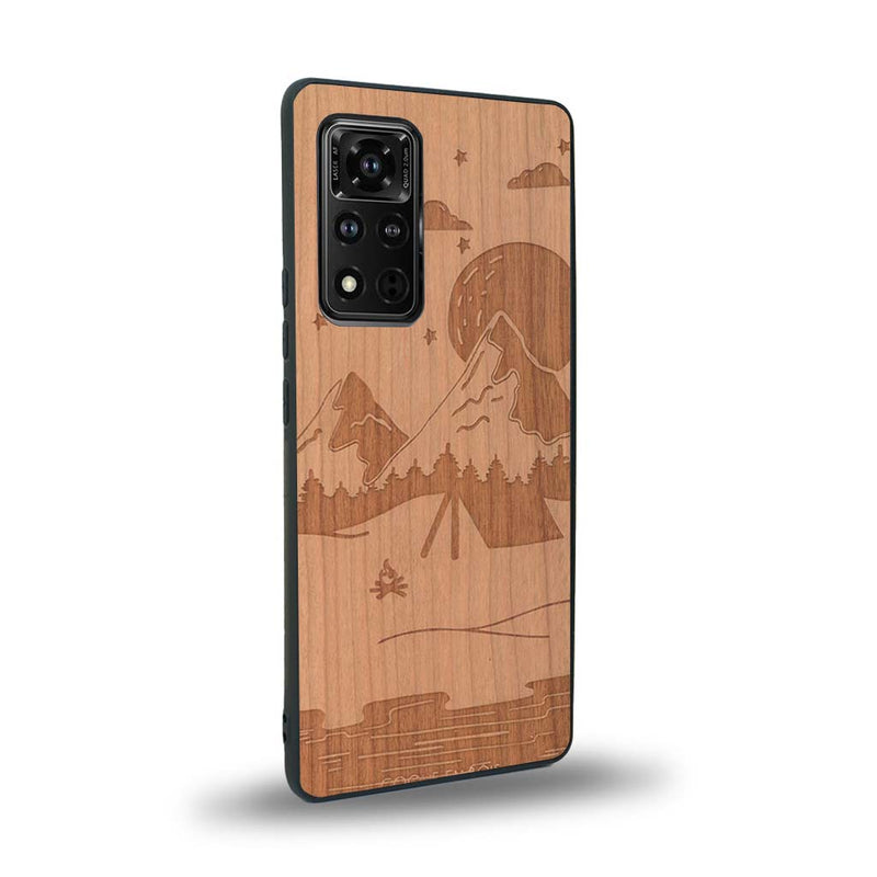 Coque de protection en bois véritable fabriquée en France pour Honor V40 sur le thème du camping en pleine nature représentant une tente avec un feu de camp entouré de montagnes