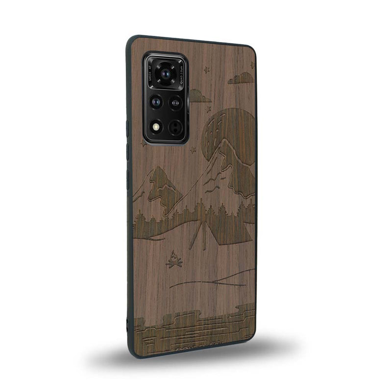 Coque de protection en bois véritable fabriquée en France pour Honor V40 sur le thème du camping en pleine nature représentant une tente avec un feu de camp entouré de montagnes