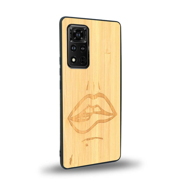 Coque de protection en bois véritable fabriquée en France pour Honor V40 représentant de manière minimaliste une bouche de féminine se mordant le coin de la lèvre de manière sensuelle dessinée à la main par l'artiste Maud Dabs