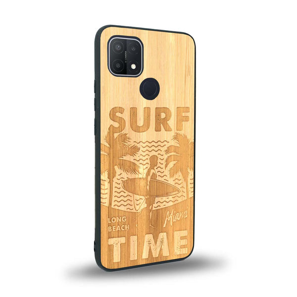 Coque de protection en bois véritable fabriquée en France pour Oppo A15 sur le thème chill avec un motif représentant une silouhette tenant une planche de surf sur une plage entouré de palmiers et les mots "Surf Time Long Beach Miami"