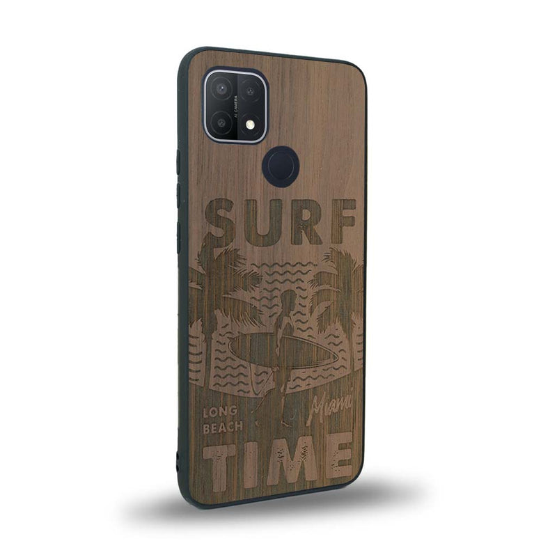 Coque de protection en bois véritable fabriquée en France pour Oppo A15 sur le thème chill avec un motif représentant une silouhette tenant une planche de surf sur une plage entouré de palmiers et les mots "Surf Time Long Beach Miami"