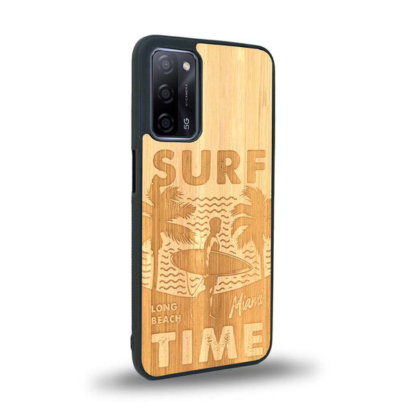 Coque de protection en bois véritable fabriquée en France pour Oppo A55 5G sur le thème chill avec un motif représentant une silouhette tenant une planche de surf sur une plage entouré de palmiers et les mots "Surf Time Long Beach Miami"