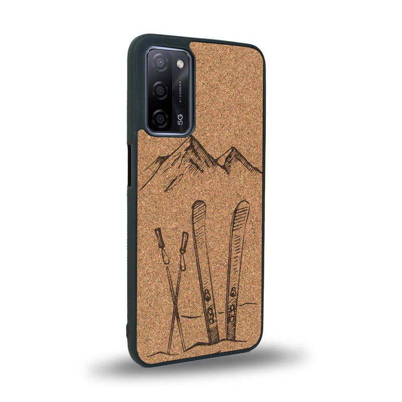 Coque de protection en bois véritable fabriquée en France pour Oppo A72 sur le thème de la montagne, du ski et de la neige avec un motif représentant une paire de ski plantée dans la neige avec en fond des montagnes enneigées