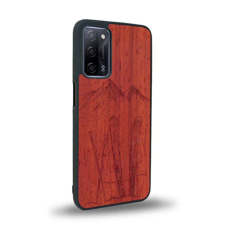 Coque de protection en bois véritable fabriquée en France pour Oppo A72 sur le thème de la montagne, du ski et de la neige avec un motif représentant une paire de ski plantée dans la neige avec en fond des montagnes enneigées