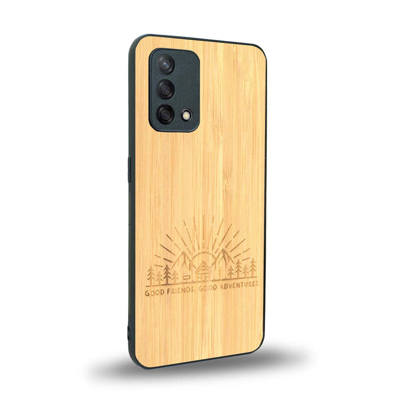 Coque de protection en bois véritable fabriquée en France pour Oppo A74 4G sur le thème chill et nature avec un motif représentant un levé de soleil sur un paysage de montagne avec des sapins et un chalet et la phrase "Good friends, good adventure"