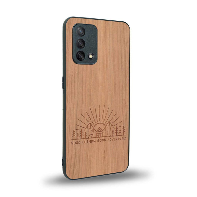 Coque de protection en bois véritable fabriquée en France pour Oppo A74 4G sur le thème chill et nature avec un motif représentant un levé de soleil sur un paysage de montagne avec des sapins et un chalet et la phrase "Good friends, good adventure"