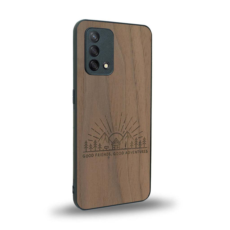 Coque de protection en bois véritable fabriquée en France pour Oppo A74 4G sur le thème chill et nature avec un motif représentant un levé de soleil sur un paysage de montagne avec des sapins et un chalet et la phrase "Good friends, good adventure"