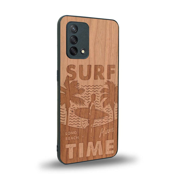 Coque de protection en bois véritable fabriquée en France pour Oppo A74 4G sur le thème chill avec un motif représentant une silouhette tenant une planche de surf sur une plage entouré de palmiers et les mots "Surf Time Long Beach Miami"