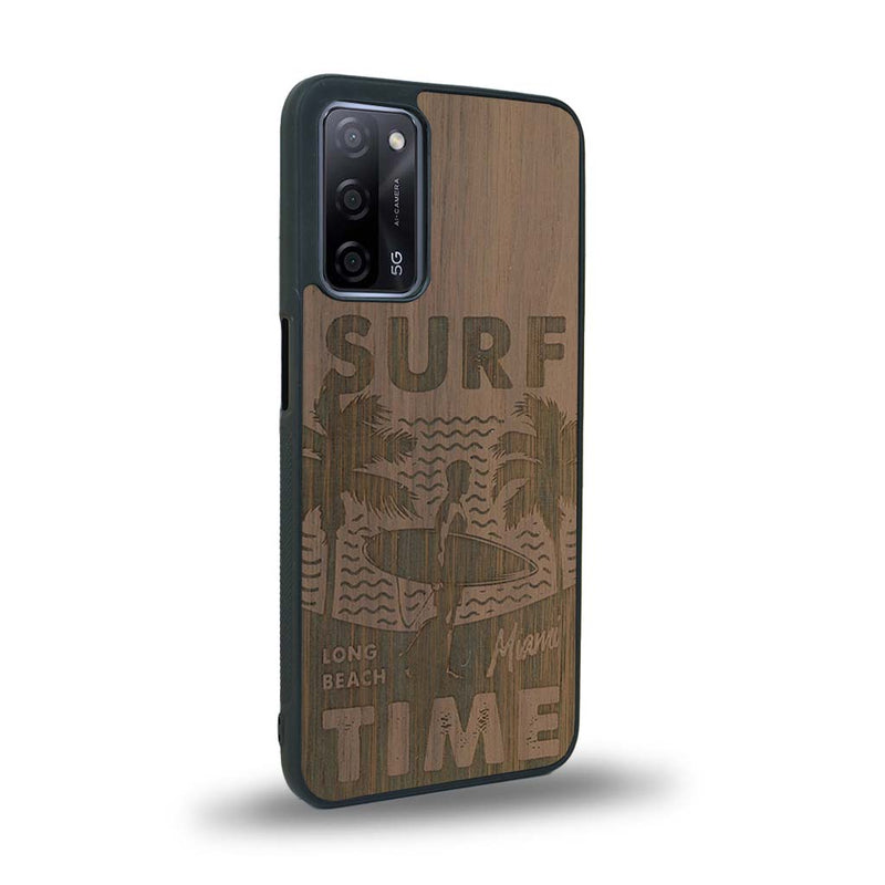 Coque de protection en bois véritable fabriquée en France pour Oppo A93 sur le thème chill avec un motif représentant une silouhette tenant une planche de surf sur une plage entouré de palmiers et les mots "Surf Time Long Beach Miami"