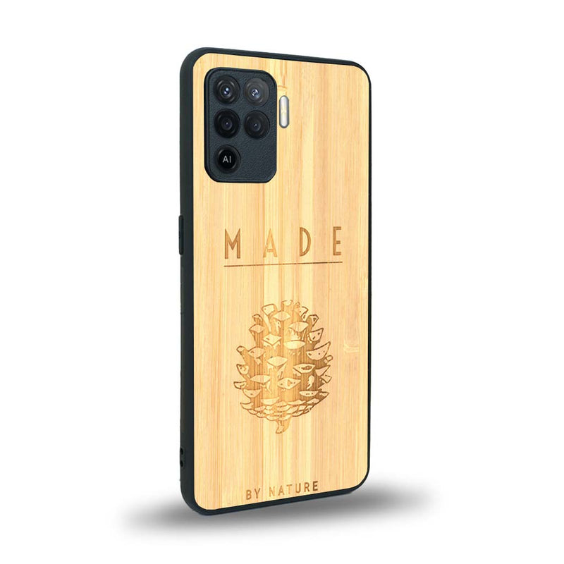 Coque de protection en bois véritable fabriquée en France pour Oppo A94 sur le thème de la nature et des arbres avec une gravure représentant une pomme de pin et la phrase "made by nature"