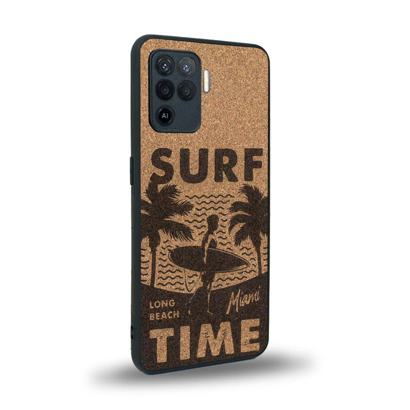 Coque de protection en bois véritable fabriquée en France pour Oppo A94 sur le thème chill avec un motif représentant une silouhette tenant une planche de surf sur une plage entouré de palmiers et les mots "Surf Time Long Beach Miami"
