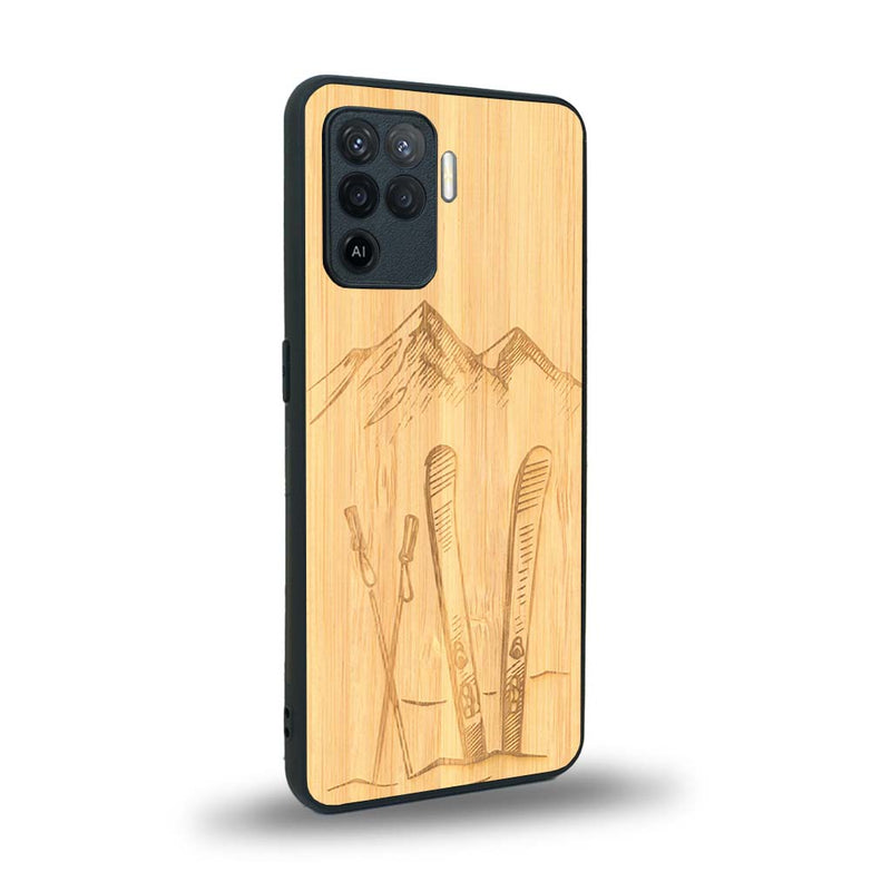 Coque de protection en bois véritable fabriquée en France pour Oppo A94 sur le thème de la montagne, du ski et de la neige avec un motif représentant une paire de ski plantée dans la neige avec en fond des montagnes enneigées