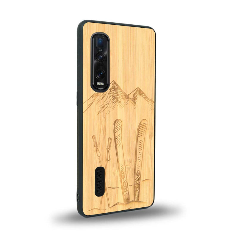 Coque de protection en bois véritable fabriquée en France pour Oppo Find X2 Pro sur le thème de la montagne, du ski et de la neige avec un motif représentant une paire de ski plantée dans la neige avec en fond des montagnes enneigées