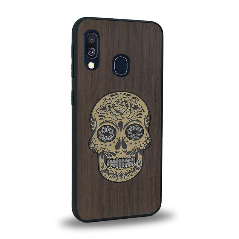 Coque de protection en bois véritable fabriquée en France pour Samsung A20E alliant du chêne fumé avec du métal argenté et doré représentant une tête de mort mexicaine sur le thème Dia de los Muertos