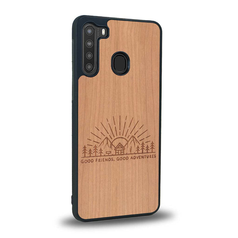 Coque de protection en bois véritable fabriquée en France pour Samsung A21 sur le thème chill et nature avec un motif représentant un levé de soleil sur un paysage de montagne avec des sapins et un chalet et la phrase "Good friends, good adventure"