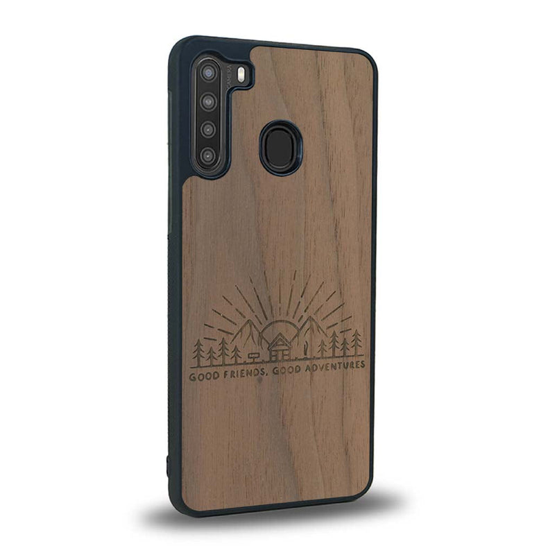 Coque de protection en bois véritable fabriquée en France pour Samsung A21 sur le thème chill et nature avec un motif représentant un levé de soleil sur un paysage de montagne avec des sapins et un chalet et la phrase "Good friends, good adventure"