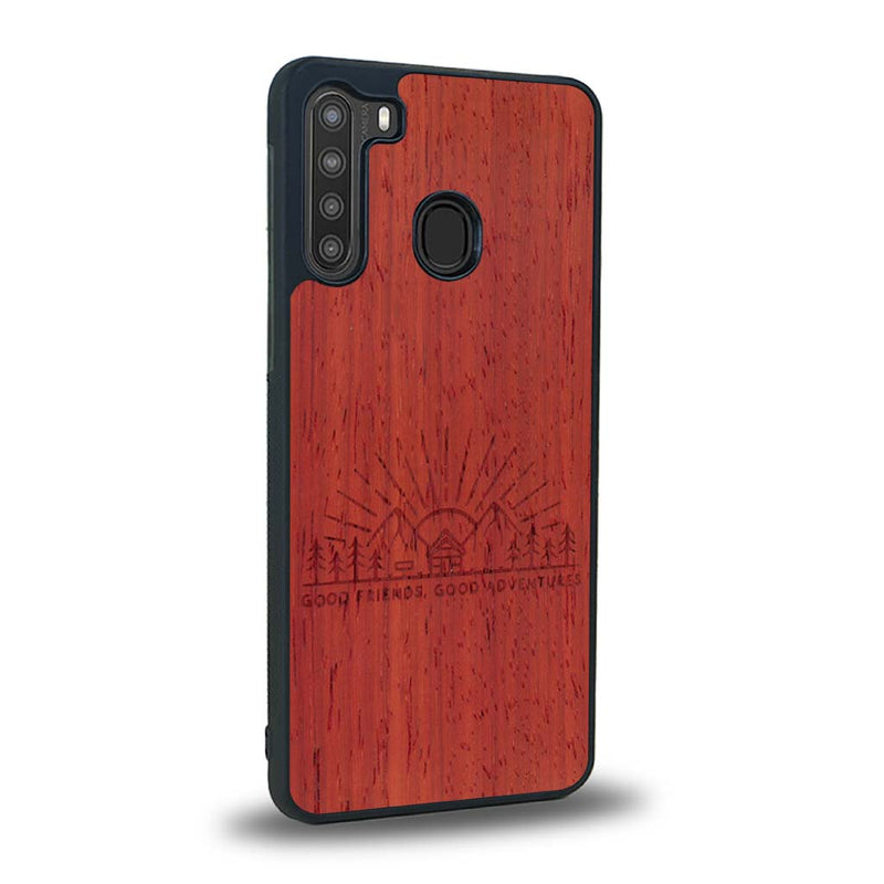 Coque de protection en bois véritable fabriquée en France pour Samsung A21 sur le thème chill et nature avec un motif représentant un levé de soleil sur un paysage de montagne avec des sapins et un chalet et la phrase "Good friends, good adventure"