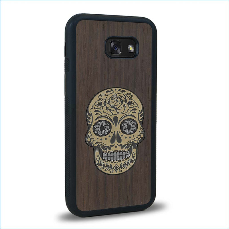 Coque de protection en bois véritable fabriquée en France pour Samsung A5 alliant du chêne fumé avec du métal argenté et doré représentant une tête de mort mexicaine sur le thème Dia de los Muertos