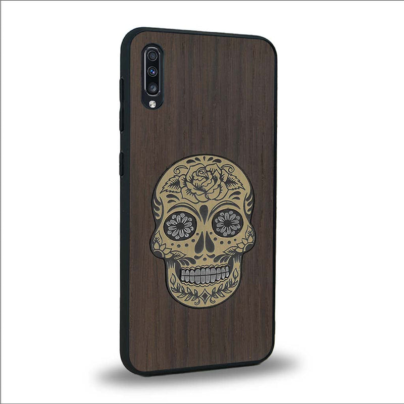 Coque de protection en bois véritable fabriquée en France pour Samsung A50 alliant du chêne fumé avec du métal argenté et doré représentant une tête de mort mexicaine sur le thème Dia de los Muertos