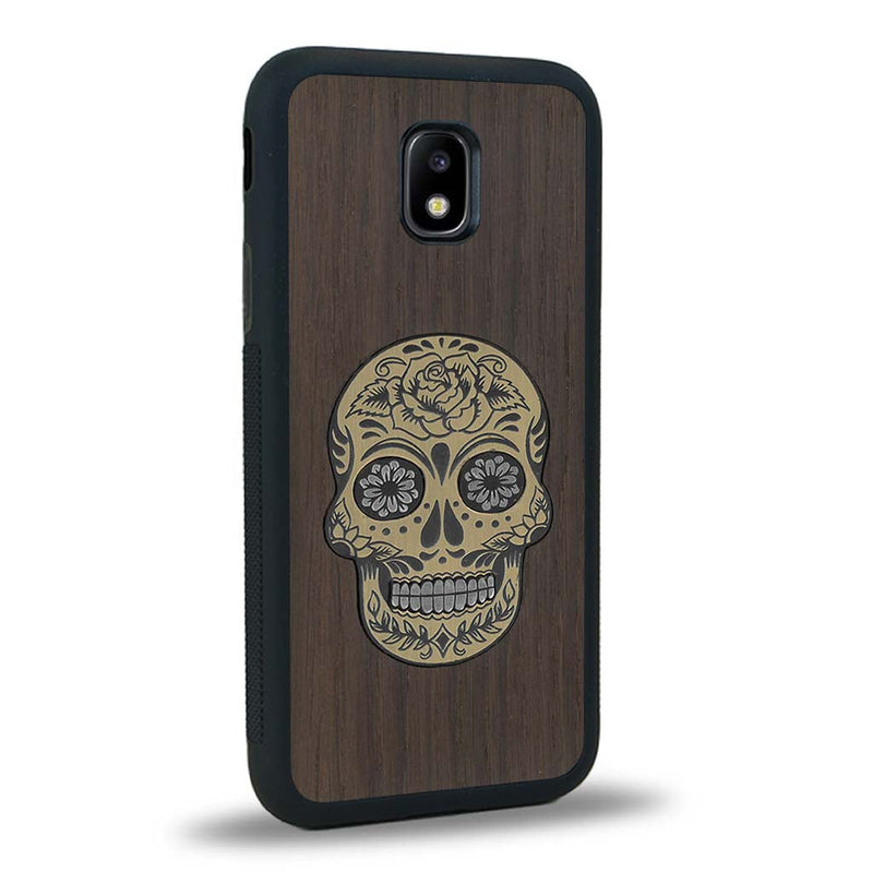 Coque de protection en bois véritable fabriquée en France pour Samsung J3 2017 alliant du chêne fumé avec du métal argenté et doré représentant une tête de mort mexicaine sur le thème Dia de los Muertos