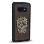 Coque de protection en bois véritable fabriquée en France pour Samsung S10E alliant du chêne fumé avec du métal argenté et doré représentant une tête de mort mexicaine sur le thème Dia de los Muertos