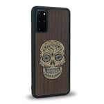 Coque de protection en bois véritable fabriquée en France pour Samsung S20FE alliant du chêne fumé avec du métal argenté et doré représentant une tête de mort mexicaine sur le thème Dia de los Muertos