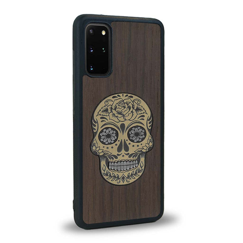 Coque de protection en bois véritable fabriquée en France pour Samsung S20+ alliant du chêne fumé avec du métal argenté et doré représentant une tête de mort mexicaine sur le thème Dia de los Muertos