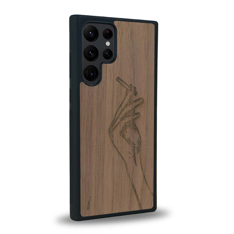 Coque de protection en bois véritable fabriquée en France pour Samsung S23 Ultra représentant une main de femme tenant une cigarette de type line art en collaboration avec l'artiste Maud Dabs