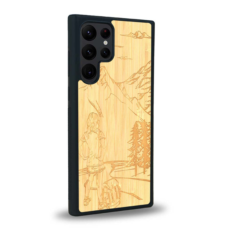 Coque de protection en bois véritable fabriquée en France pour Samsung S23 Ultra sur le thème de la randonnée en montagne et de l'aventure avec une gravure représentant une femme de dos face à un paysage de nature