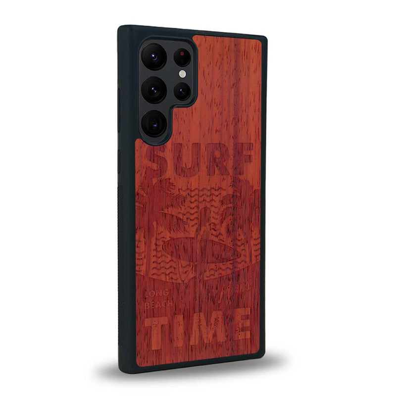 Coque de protection en bois véritable fabriquée en France pour Samsung S23 Ultra sur le thème chill avec un motif représentant une silouhette tenant une planche de surf sur une plage entouré de palmiers et les mots "Surf Time Long Beach Miami"