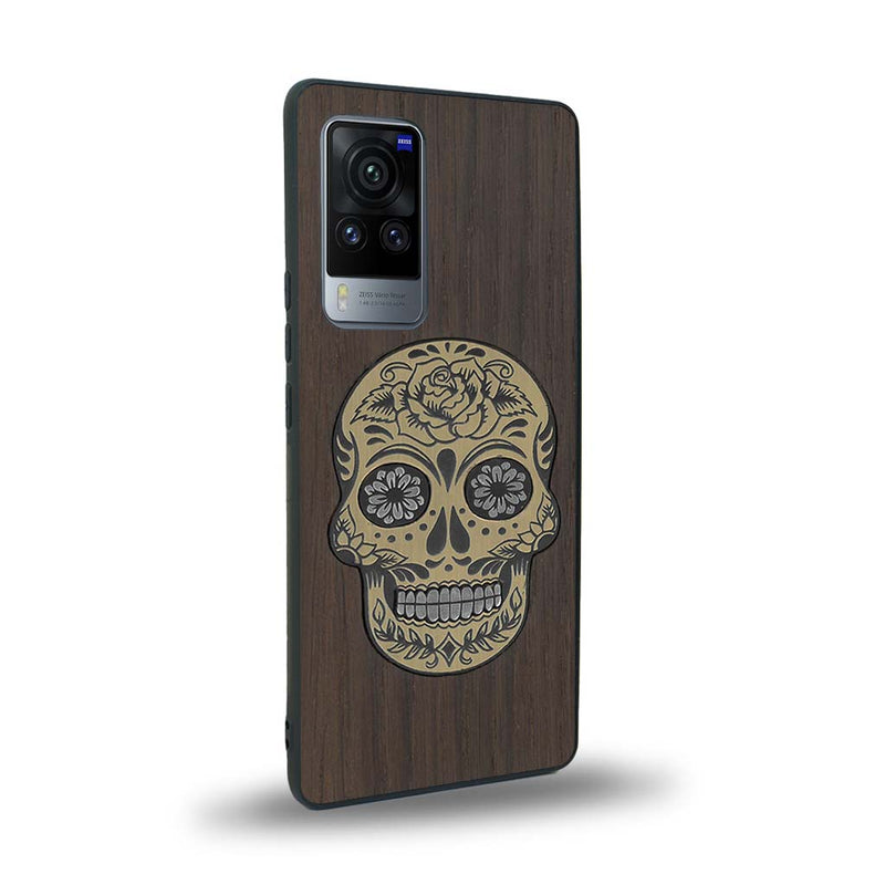 Coque de protection en bois véritable fabriquée en France pour Vivo X60 alliant du chêne fumé avec du métal argenté et doré représentant une tête de mort mexicaine sur le thème Dia de los Muertos