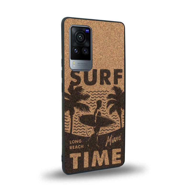 Coque de protection en bois véritable fabriquée en France pour Vivo X60 sur le thème chill avec un motif représentant une silouhette tenant une planche de surf sur une plage entouré de palmiers et les mots "Surf Time Long Beach Miami"