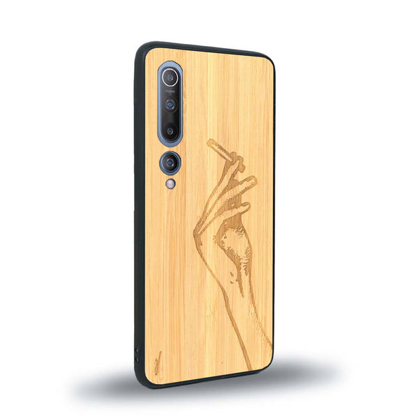 Coque de protection en bois véritable fabriquée en France pour Xiaomi Mi 10 représentant une main de femme tenant une cigarette de type line art en collaboration avec l'artiste Maud Dabs