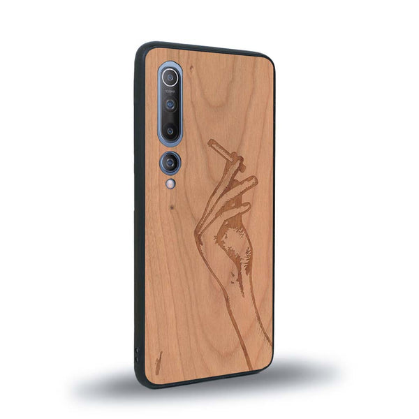 Coque de protection en bois véritable fabriquée en France pour Xiaomi Mi 10 représentant une main de femme tenant une cigarette de type line art en collaboration avec l'artiste Maud Dabs