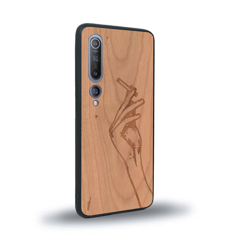 Coque de protection en bois véritable fabriquée en France pour Xiaomi Mi 10 représentant une main de femme tenant une cigarette de type line art en collaboration avec l'artiste Maud Dabs