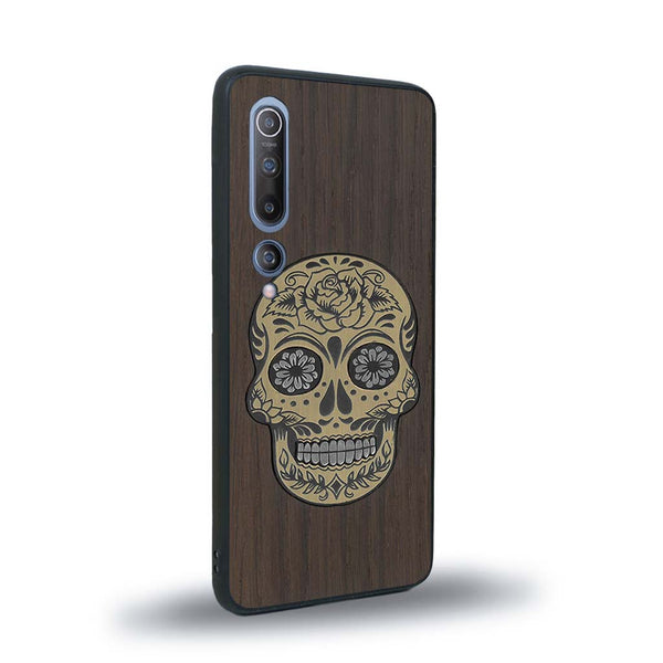 Coque de protection en bois véritable fabriquée en France pour Xiaomi Mi 10 alliant du chêne fumé avec du métal argenté et doré représentant une tête de mort mexicaine sur le thème Dia de los Muertos