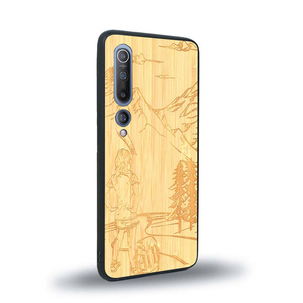 Coque de protection en bois véritable fabriquée en France pour Xiaomi Mi 10 sur le thème de la randonnée en montagne et de l'aventure avec une gravure représentant une femme de dos face à un paysage de nature