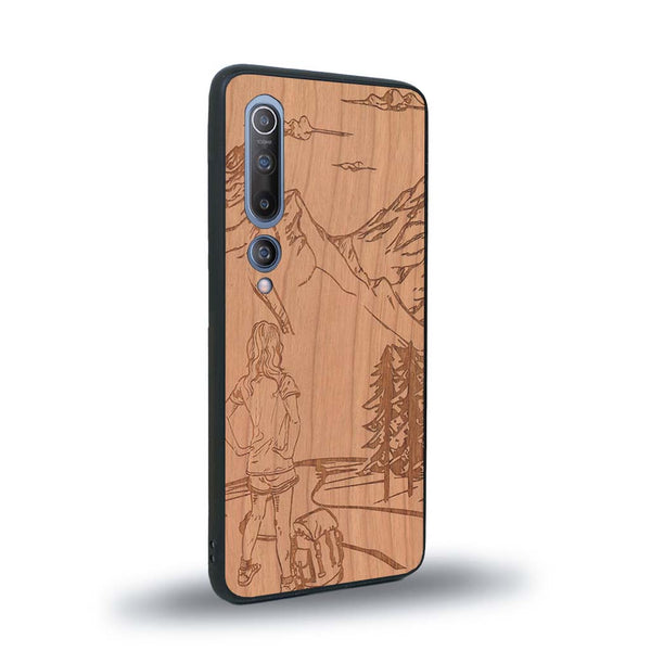 Coque de protection en bois véritable fabriquée en France pour Xiaomi Mi 10 sur le thème de la randonnée en montagne et de l'aventure avec une gravure représentant une femme de dos face à un paysage de nature
