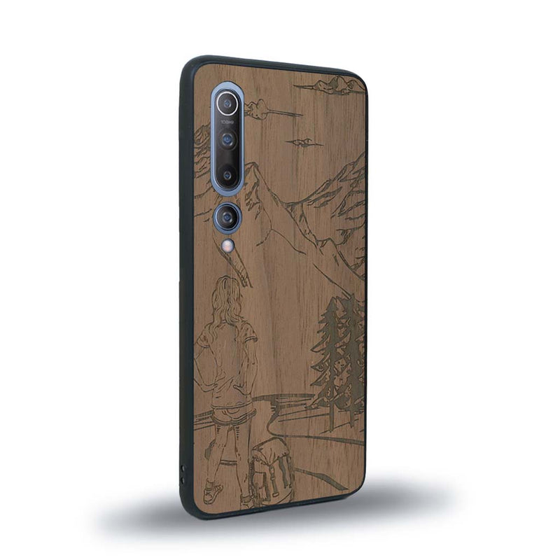 Coque de protection en bois véritable fabriquée en France pour Xiaomi Mi 10 sur le thème de la randonnée en montagne et de l'aventure avec une gravure représentant une femme de dos face à un paysage de nature