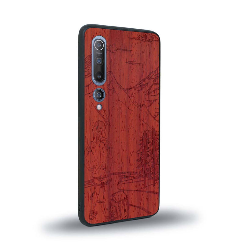 Coque de protection en bois véritable fabriquée en France pour Xiaomi Mi 10 sur le thème de la randonnée en montagne et de l'aventure avec une gravure représentant une femme de dos face à un paysage de nature